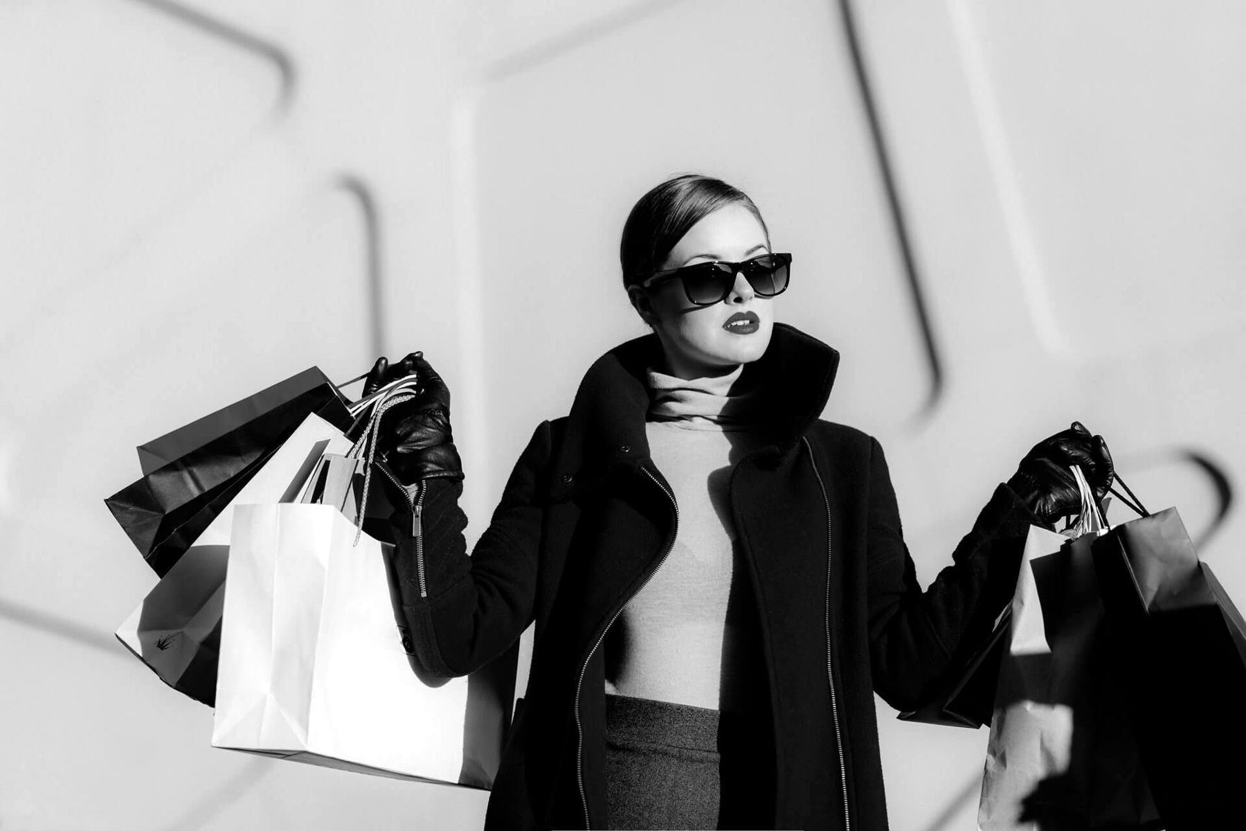 Cliente Accessor en manteau noir et lunettes de soleil, sacs à la main